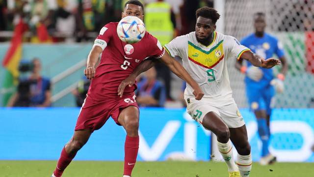 O meio-campista Abdelaziz, do Catar (à esquerda), disputa uma jogada com o atacante Boulaye Dia, de Senegal, que foi autor do primeiro gol da vitória por 3 a 1